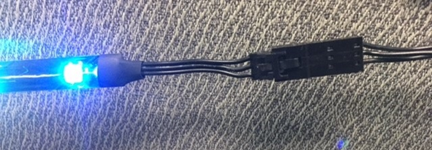 LED light with connected wires on a textured surface.