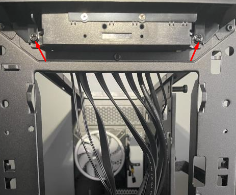 Interior of a computer case with cables and screws.
