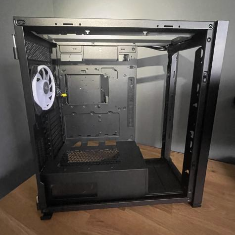 Open computer case on a wooden surface.